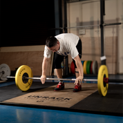 Person preparing to lift a barbell with weights on a lifting platform in a gym setting